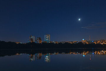 Beautiful view of the night city. Right bank of the Dnieper, lights in the night river. View of beautiful modern buildings.