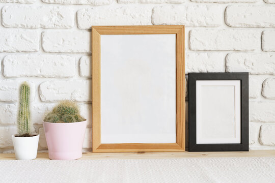 Square wooden photo frame and cactus plants on the table