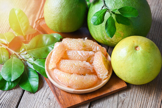 pomelo fruit on wooden plate  background, fresh green pomelo peeled and leaf frome pomelo tree , pummelo , grapefruit in summer tropical fruit  in thailand