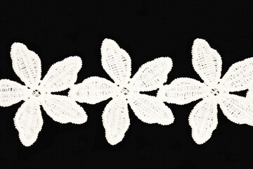 White lace in shape of stars on black background isolated. Sewing concept