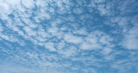 Deep blue skies with white clouds background with space for text, blue cloudy skies texture. front view