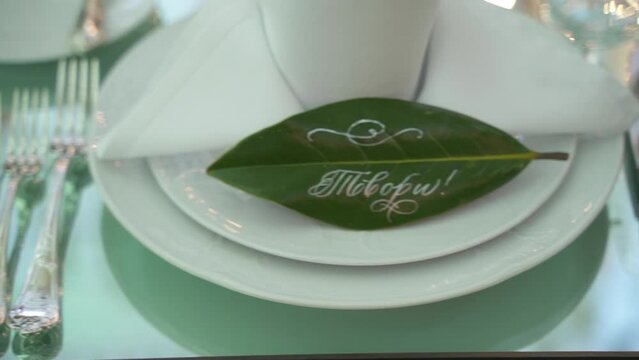 Laconic, minimalistic table setting. White plates on knitted napkins, glass glasses. Dinner table for people in nature. Sunny day. Celebrated. High quality FullHD footage