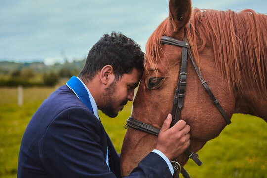 Dark-haired boy hugging his horse after a ride