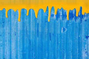Abstract Blue colored concrete wall with liquid yellow oil paint texture, background. Brush stroke pattern backdrop 