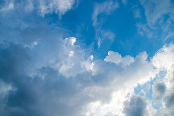 Background with white clouds on blue sky. Pattern on the theme of nature, tranquility and serenity.