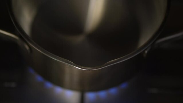 boiling water in a pot. Burning gas, gas stove burner, hob in the kitchen. The concept of problems with natural gas, rising gas prices, and wastage.