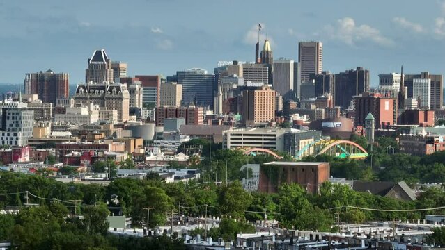 Rising aerial reveal of downtown Baltimore city skyline on summer day. Tight long zoom.