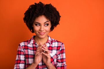Photo of cunning funky lady dressed checkered shirt arms together looking empty space isolated orange color background