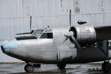 Light twin-engine aircraft in front of hangar