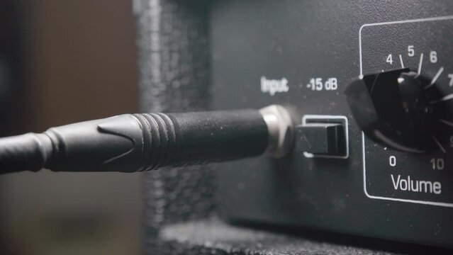 Plugging an instrument cable into a guitar amplifier