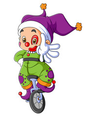 The happy clown boy is cycling with the one wheels