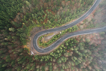 Picturesque mountains and serpentine roads, forest and road in the fog, steep turns of roads, road in the mountains.