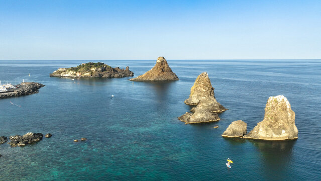 faraglioni acitrezza sul mare blu al tramonto visti dall'alto