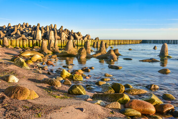 breakwater and beach in the first rays of sun, Baltic Sea in Poland