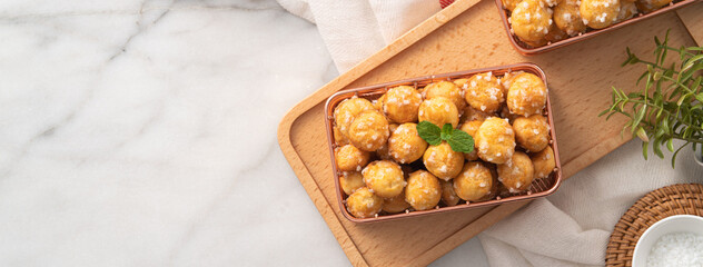 Delicious French Chouquette Choux Pastry dessert Pearl Sugar Puff on white marble background.