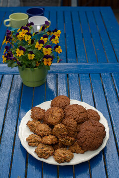 Cookies and yellow flowers are on the blue table.