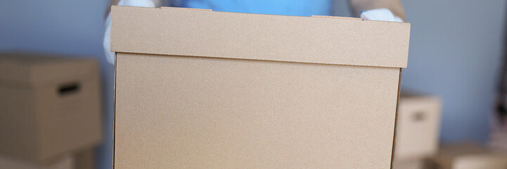 Fototapeta premium Worker loading cardboard boxes with owners belongings to new apartment