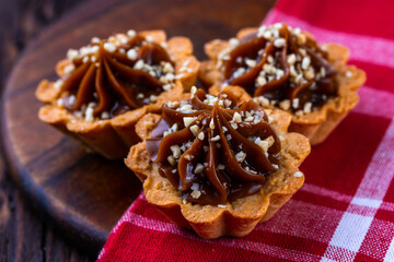 A cup of black tea and a plate with homemade bakery, biscuit on a wooden table. Close-up.