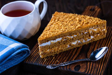 A cup of black tea and a plate with homemade bakery, biscuit on a wooden table. Close-up.
