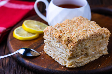 A cup of black tea and a plate with homemade bakery, biscuit on a wooden table. Close-up.
