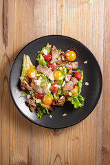 traditional dishes of European cuisine, delicacy, banquet snack. culinary dishes on a black plate on a wood background. restaurant service. top view