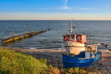 fishing boats and a breakwater in the first rays of the sun, the Baltic Sea in Poland