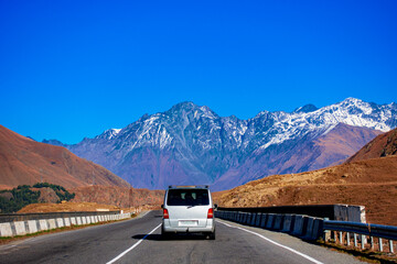 The minibus rides on a mountain road.