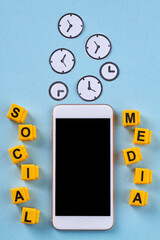 Concept of time waste in social media. Smartphone with clock pictures on blue background.