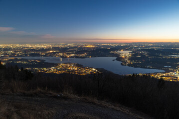 Aerial view of Lombardy and northern Italy at dusk with Lake Varese in the foreground and the Apennines on the horizon. Panorama at sunset from the Campo dei Fiori regional park in Varese