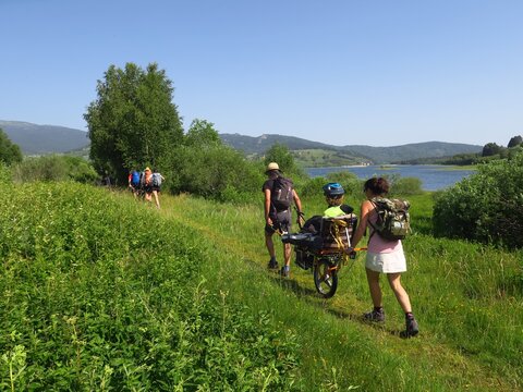 Randonn&eacute;e en montagne solidaire avec handicap&eacute; en joelette fauteuil roulant de randonn&eacute;e sur les sentiers avec des gens et personne en handicap