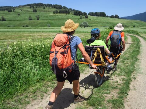 Randonn&eacute;e en montagne solidaire avec handicap&eacute; en joelette fauteuil roulant de randonn&eacute;e sur les sentiers avec des gens et personne en handicap