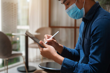 Close up hands Businessman using tablet connecting wifi at cafe with working in the morning.