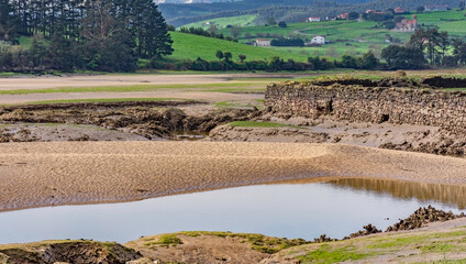 estuary landscape with low tide and blue sky with clouds - 512293489