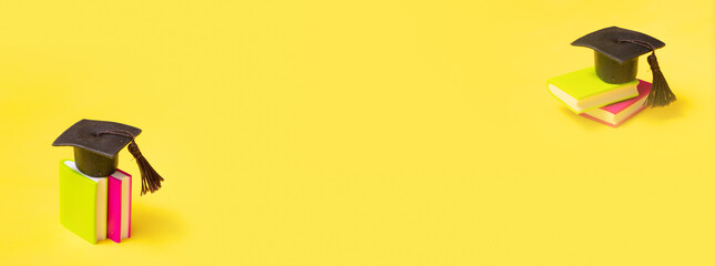 Graduation cap on colorful books on yellow background banner format. Education concept with copy space