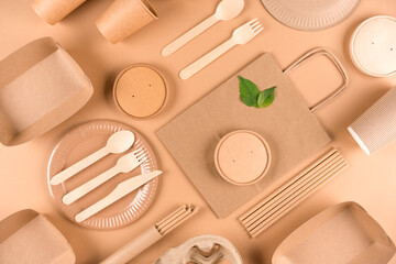 Paper utensils and wooden cutlery set over light brown background. Street food sustainable paper...
