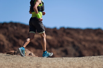 Trail running athlete exercising for fitness and health outdoors on mountain pathway