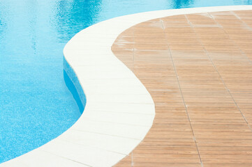 Swimming pool with clean blue water under the bright sunlight.