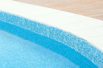 Swimming pool with clean blue water under the bright sunlight.