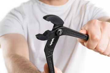A close up image of man holding repair tool pliers on white background. Repairman is tryinig to fix...