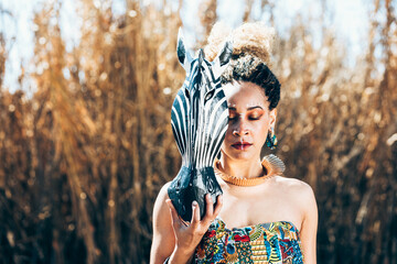 Mixed race female with African zebra mask