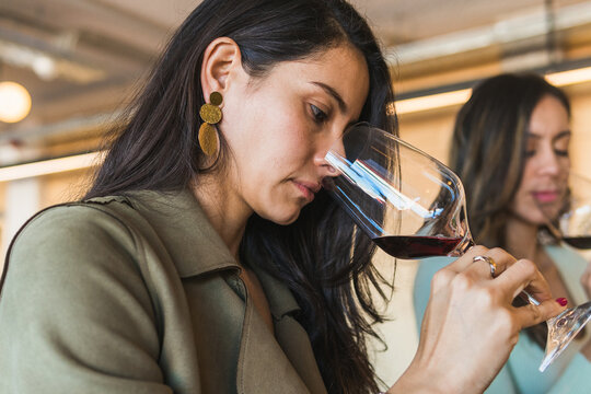 Women smelling drinks during wine tasting session