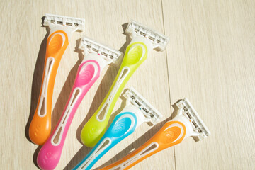 razors of different colors for women on a light background, with a place for text. Beauty, care,...