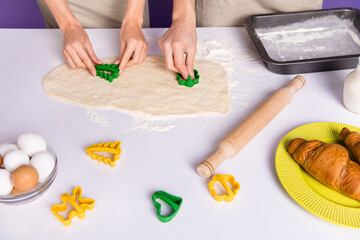 Cropped photo of two people hands make prepare cookie forms isolated on violet color background