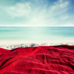Red towel on sand and free space for your decoration. 