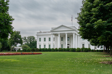 Fototapeta na wymiar Front View of the White House and Green Grass With Cloudy Skies