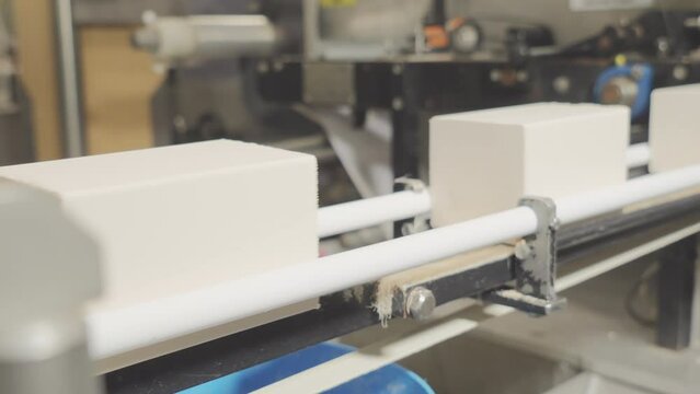 Conveyor of the food industry. An enterprise that produces butter, spread, margarine, yeast. Rectangular pieces of product move along the line before packing