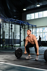 Obraz na płótnie Canvas Athletic man doing overhead barbell press in hardcore gym