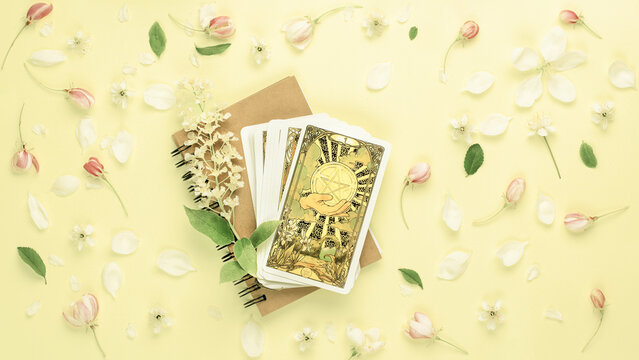 Blurred yellow flowers background with Tarot cards. Esoteric concept, fortune telling and predictions