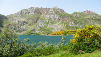 Lago entre montañas rocosas en valle verde