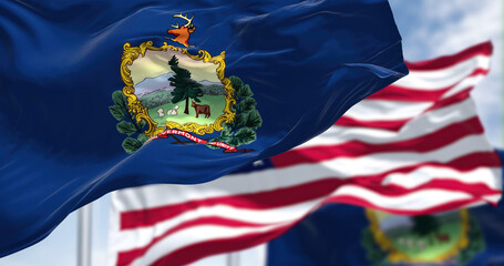 The Vermont state flag waving along with the national flag of the United States of America
